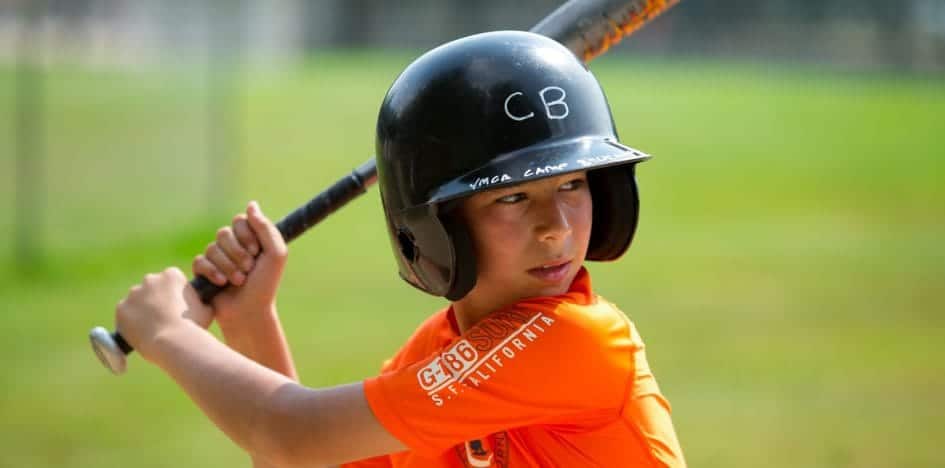 young boy with a baseball bat ready to swing