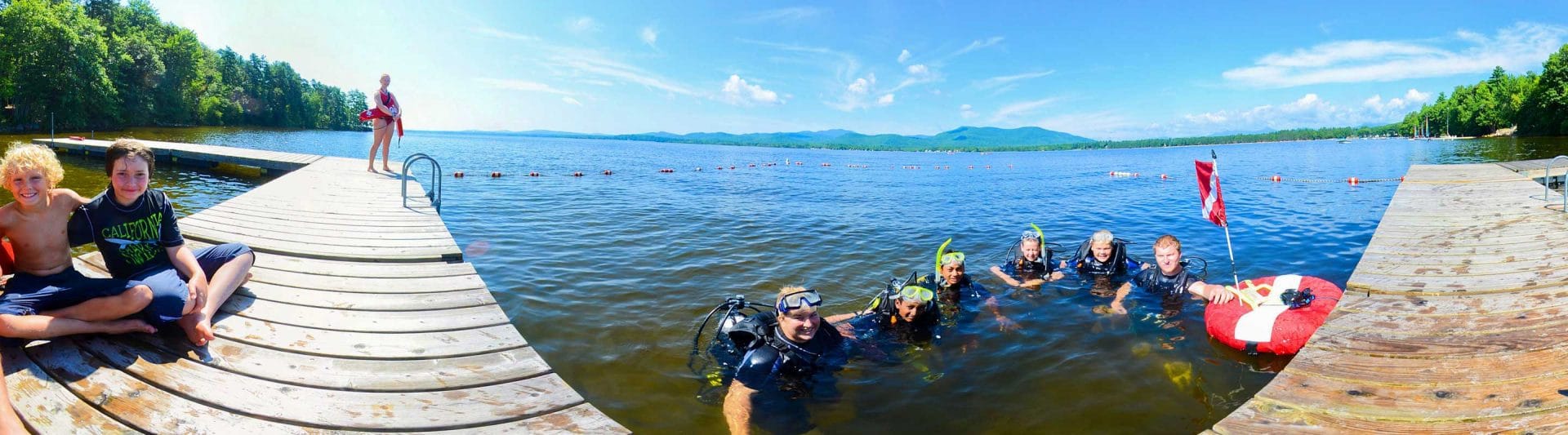 group of young campers practicing scuba diving at the lake