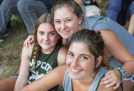 three girls hugging and smiling